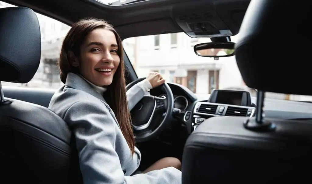Post Breast Augmentation Driver looking in back seat checking on their recovery.